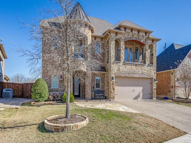 view of front facade with a garage, a front lawn, a balcony, and central AC unit