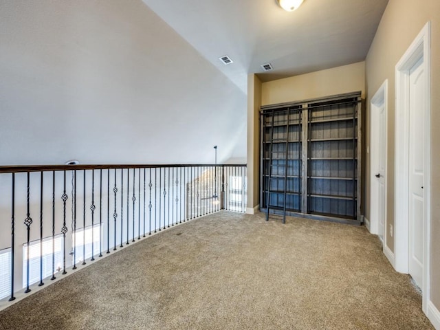 spare room with carpet floors and vaulted ceiling