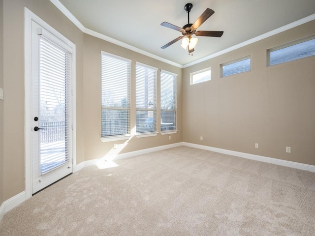 empty room with ceiling fan, a healthy amount of sunlight, light carpet, and ornamental molding