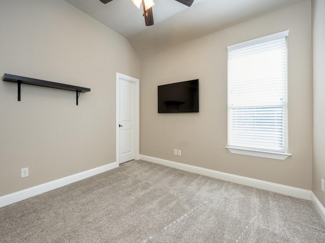 interior space with lofted ceiling, light colored carpet, and ceiling fan