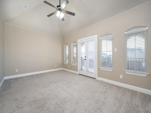 carpeted empty room featuring ceiling fan, lofted ceiling, and french doors