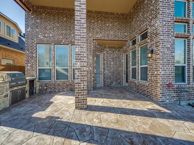 view of patio / terrace featuring exterior kitchen and a grill