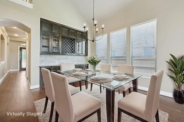 1776 Halifax St, Roanoke, TX 76262 - dining room featuring arched walkways, a chandelier, dark wood-style floors, vaulted ceiling, and baseboards