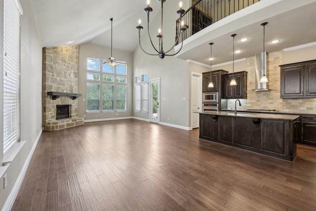 1776 Halifax St, Roanoke, TX 76262 - kitchen with wall chimney range hood, appliances with stainless steel finishes, ceiling fan, a sink, and dark brown cabinets