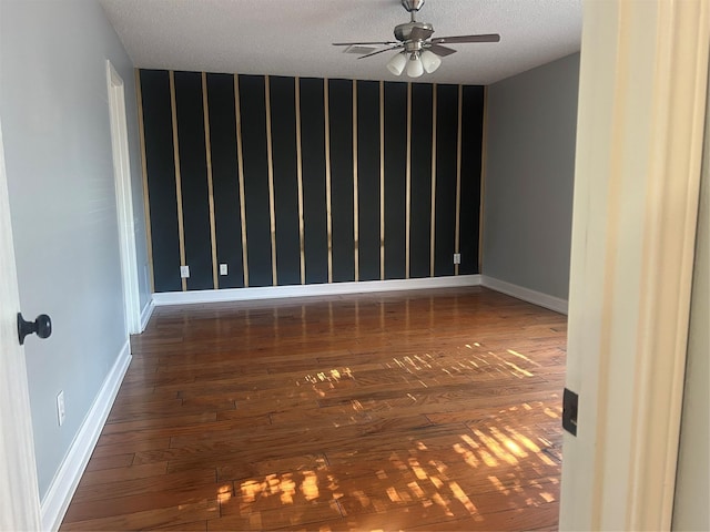 spare room featuring ceiling fan, dark hardwood / wood-style flooring, and a textured ceiling