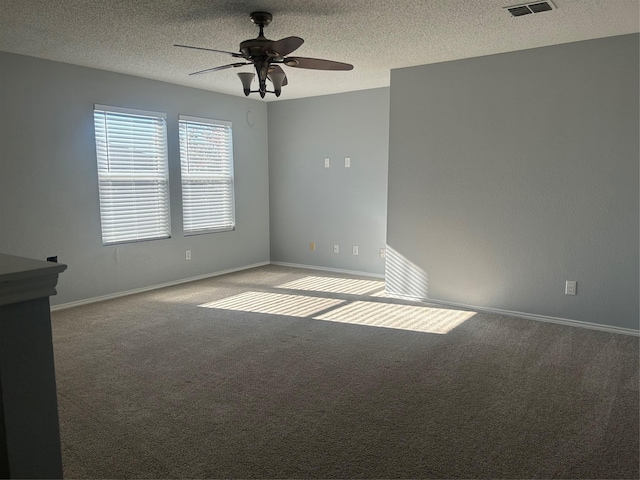 unfurnished room with a textured ceiling, ceiling fan, and light colored carpet