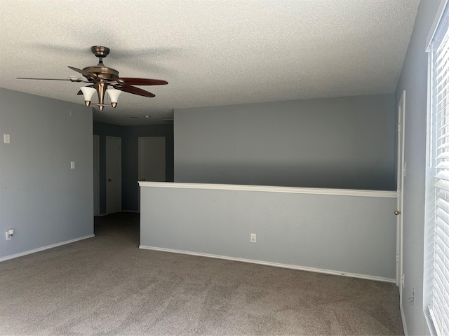 empty room featuring ceiling fan, a textured ceiling, and carpet flooring