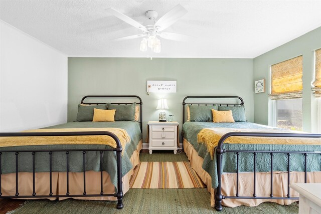 bedroom with ceiling fan and a textured ceiling