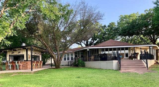 view of front of house featuring a front lawn and exterior bar