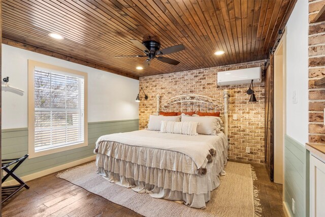 bedroom featuring a wainscoted wall, brick wall, hardwood / wood-style floors, an AC wall unit, and wooden ceiling
