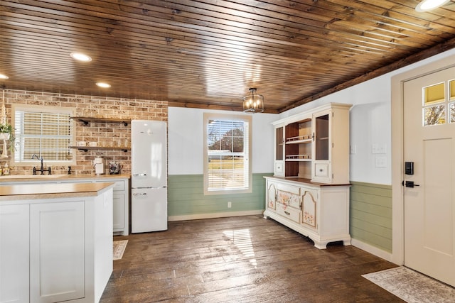 kitchen with freestanding refrigerator, wood ceiling, a sink, and open shelves