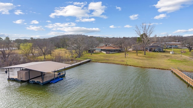 dock area with a lawn and a water view