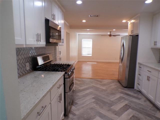 kitchen featuring light stone countertops, white cabinetry, and appliances with stainless steel finishes