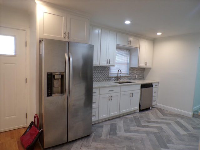 kitchen featuring decorative backsplash, sink, white cabinets, and stainless steel appliances