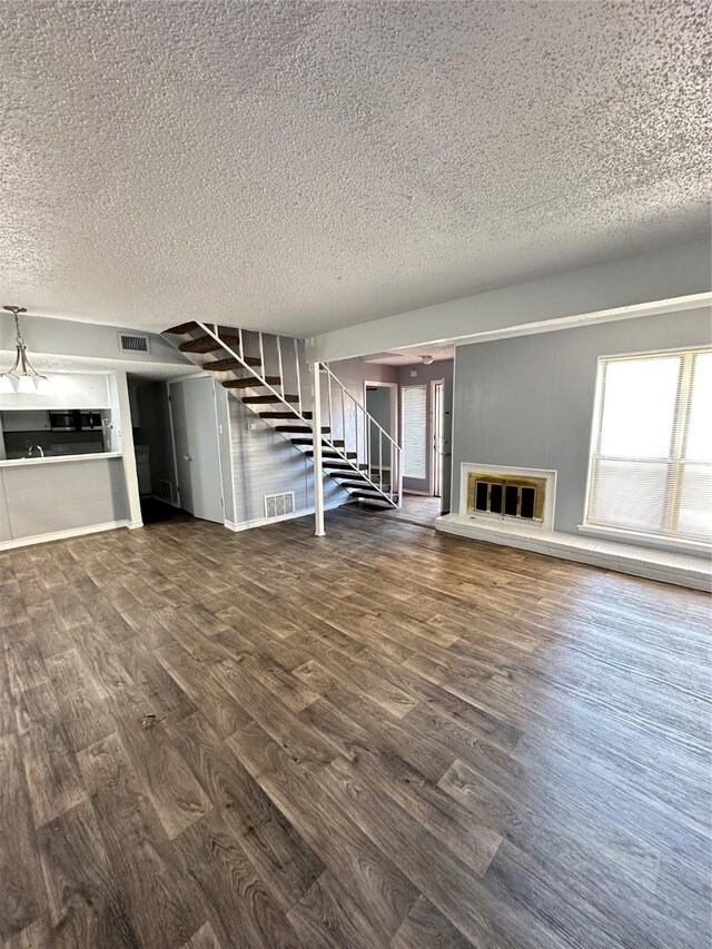 kitchen featuring dark wood-type flooring, a textured ceiling, sink, and refrigerator with ice dispenser