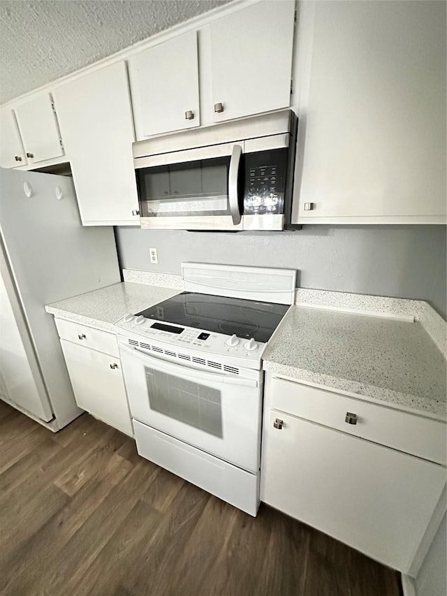 kitchen featuring dark hardwood / wood-style floors, white appliances, and white cabinetry