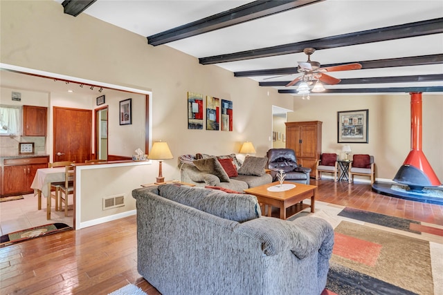 living room featuring ceiling fan, beam ceiling, and hardwood / wood-style flooring