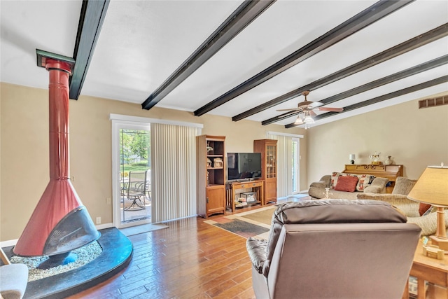 living room with light hardwood / wood-style floors, ceiling fan, and beamed ceiling