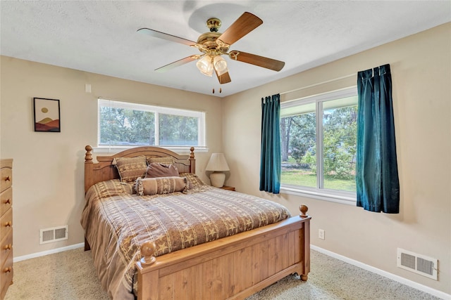 bedroom featuring ceiling fan, multiple windows, and a textured ceiling