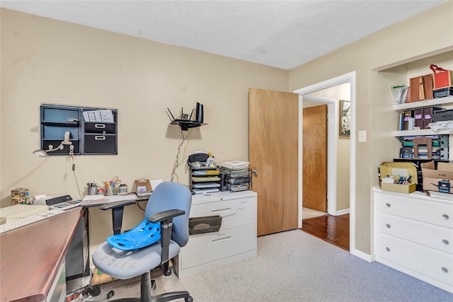 office area with light colored carpet and a textured ceiling