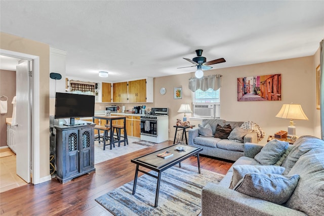 living room featuring ceiling fan, cooling unit, and dark hardwood / wood-style flooring