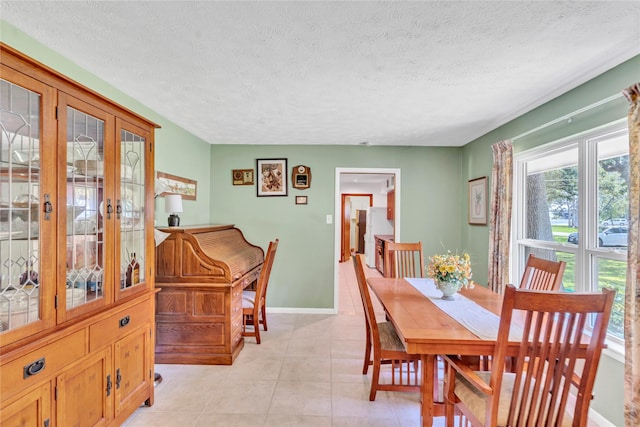 tiled dining space with a textured ceiling