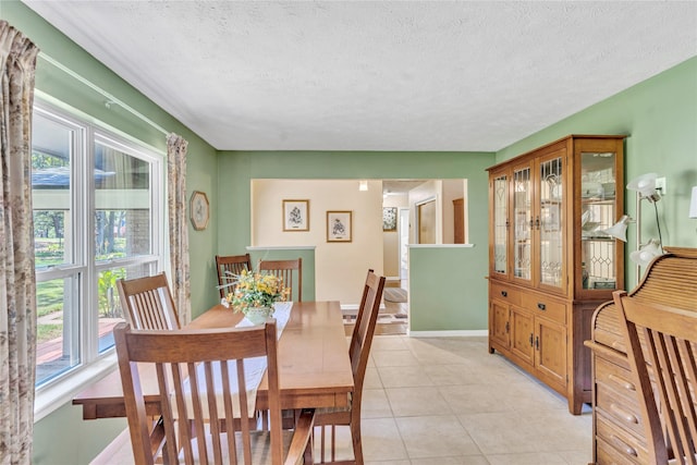 dining room featuring plenty of natural light, a textured ceiling, and light tile patterned floors