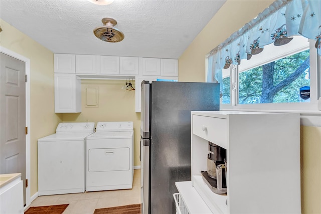 clothes washing area with light tile patterned floors, washing machine and clothes dryer, and a textured ceiling