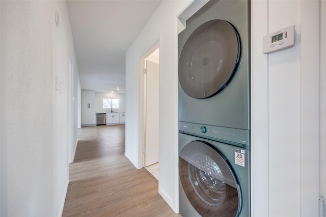 washroom featuring stacked washer and dryer and light wood-type flooring