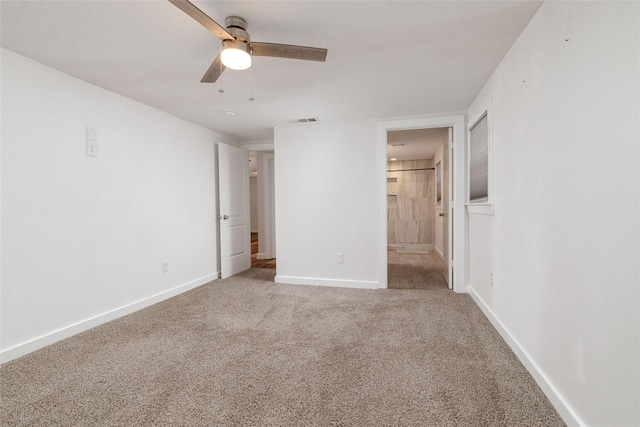 unfurnished bedroom with ceiling fan, connected bathroom, and carpet flooring