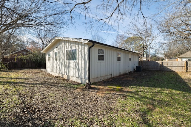 view of side of property featuring central AC unit and a yard