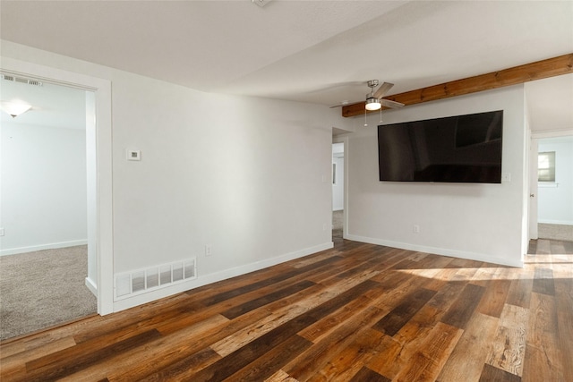 empty room featuring dark wood-type flooring, beamed ceiling, and ceiling fan