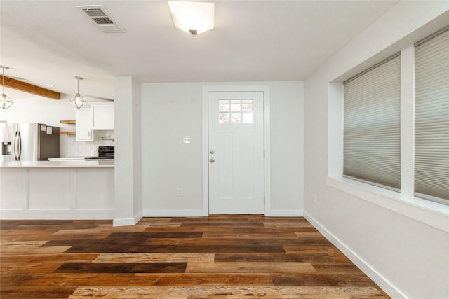 entryway with dark hardwood / wood-style flooring and beamed ceiling