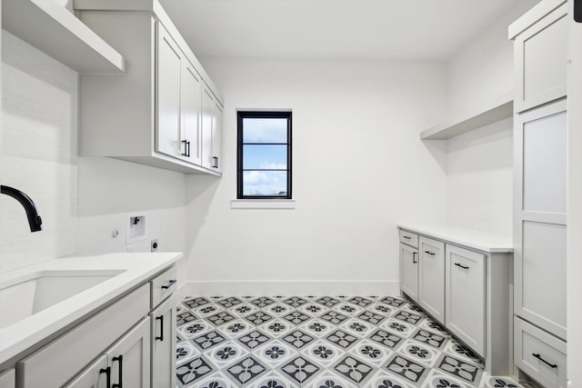 clothes washing area featuring washer hookup, sink, hookup for an electric dryer, and cabinets