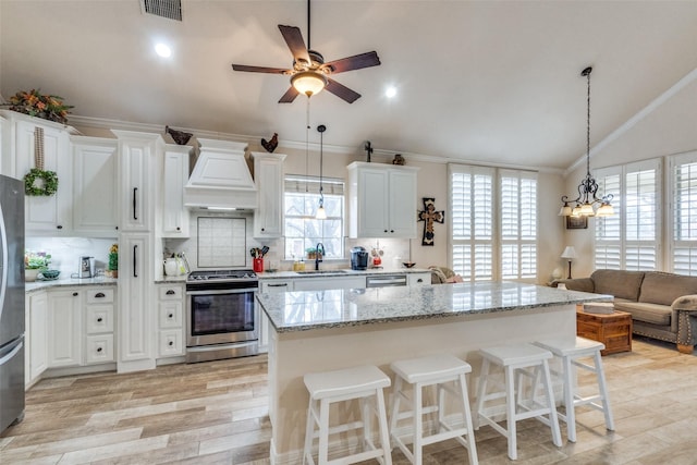 kitchen with stainless steel appliances, hanging light fixtures, sink, and a kitchen island