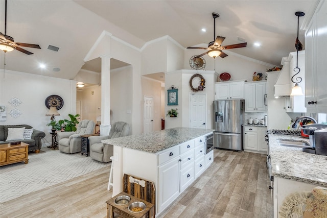 kitchen featuring ornate columns, a kitchen island, white cabinetry, stainless steel refrigerator with ice dispenser, and light hardwood / wood-style flooring