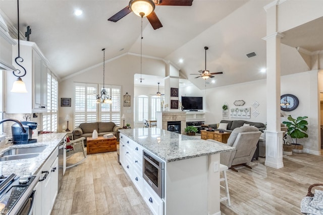 kitchen featuring sink, white cabinetry, a center island, stainless steel appliances, and light hardwood / wood-style floors