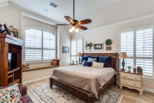 bedroom featuring ceiling fan, ornamental molding, lofted ceiling, and light wood-type flooring