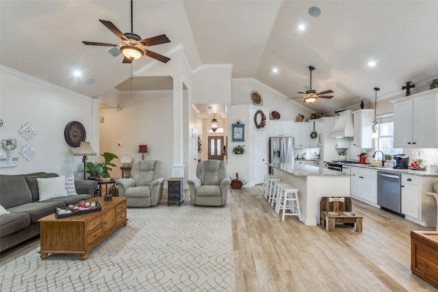 living room featuring lofted ceiling, sink, crown molding, ceiling fan, and light hardwood / wood-style floors