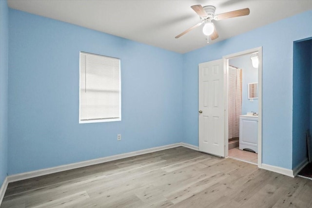 unfurnished bedroom featuring ceiling fan, ensuite bath, and light wood-type flooring