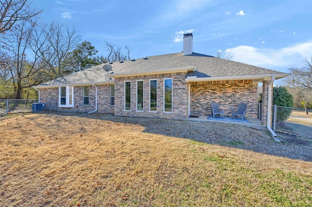 rear view of house with a yard, central AC unit, and a patio area