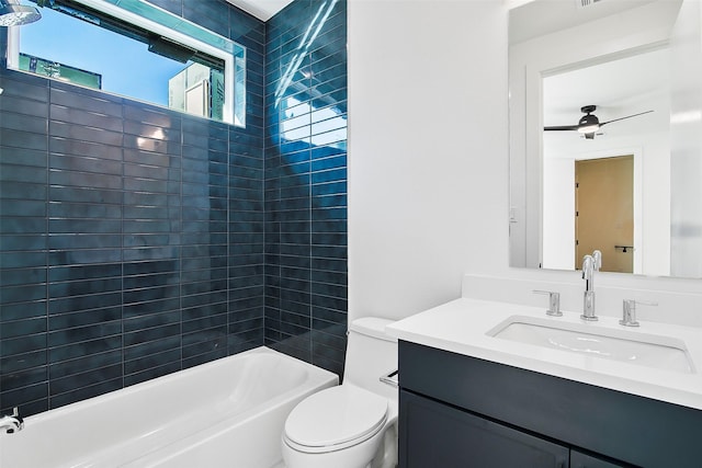 full bathroom with ceiling fan, vanity, toilet, and tiled shower / bath