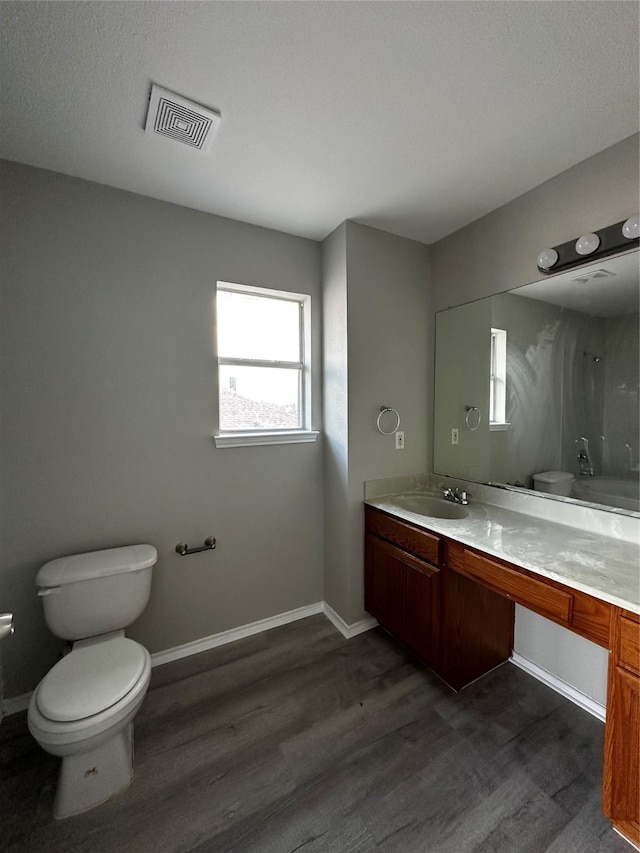 bathroom featuring toilet, hardwood / wood-style flooring, and vanity