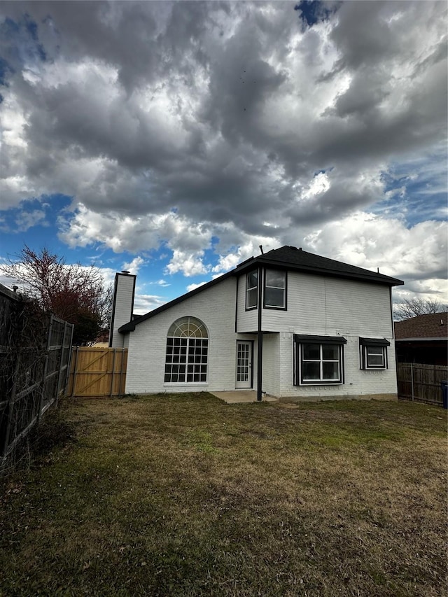 back of house featuring a lawn