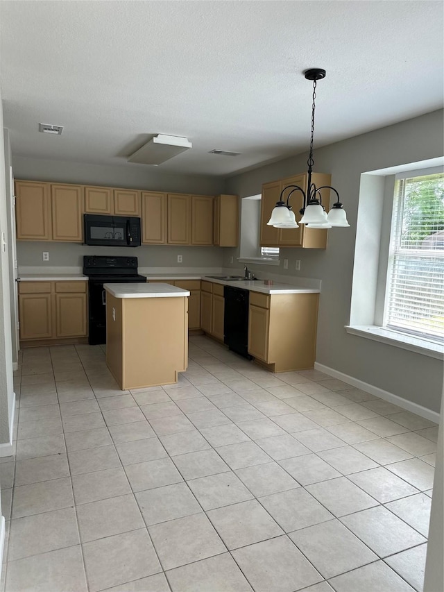 kitchen featuring black appliances, light countertops, a center island, a chandelier, and baseboards