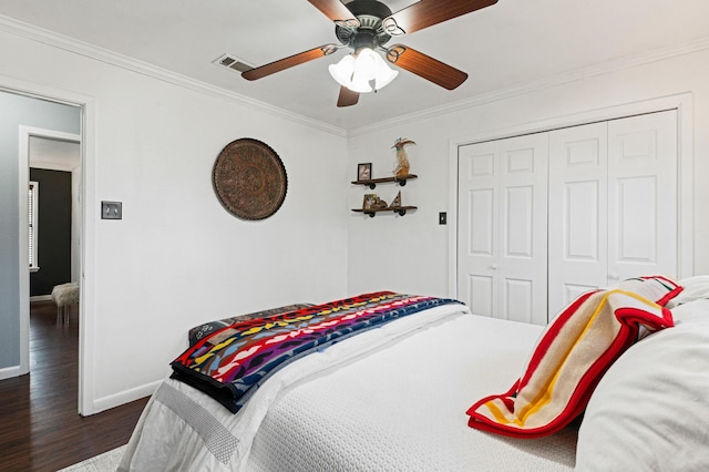 bedroom with ceiling fan, dark hardwood / wood-style flooring, a closet, and crown molding