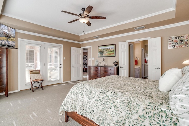 carpeted bedroom with ceiling fan, crown molding, a tray ceiling, and access to outside