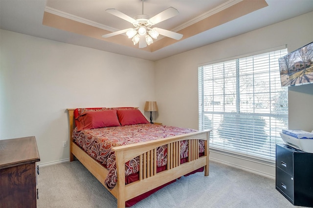 bedroom with ceiling fan, a tray ceiling, and carpet flooring