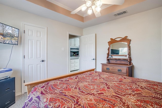 bedroom with ceiling fan, a tray ceiling, and crown molding