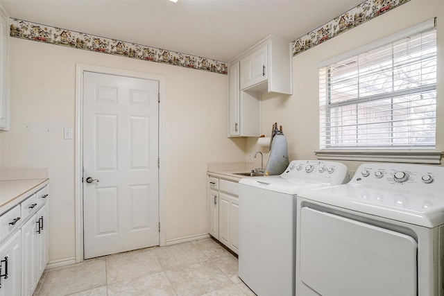 laundry area featuring cabinets, washer and clothes dryer, and sink